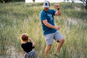Little girl dancing with father in a field