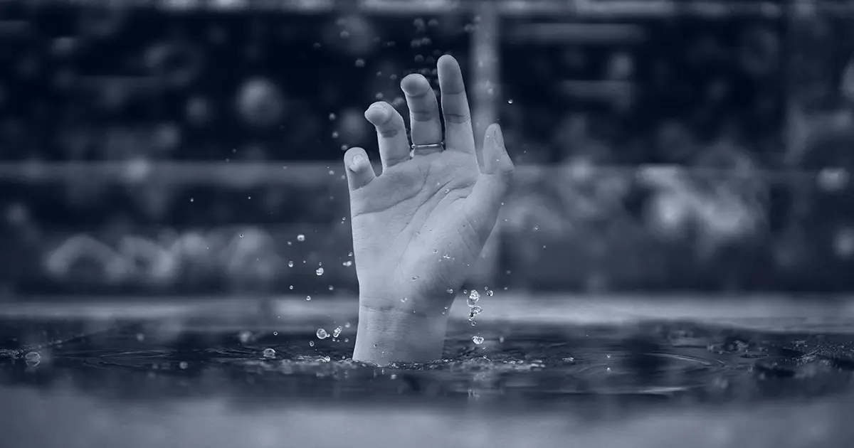 hand disappearing into water symbolic of person drowning